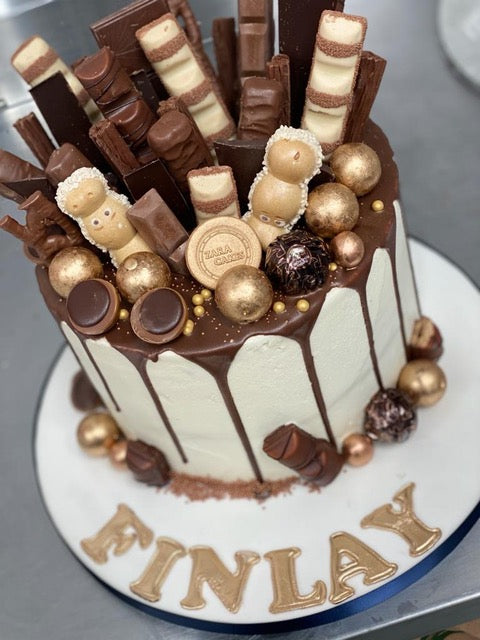Iced - Cake Design - Chocolate drip cake with kinder surprise egg and bars  on top! | Facebook